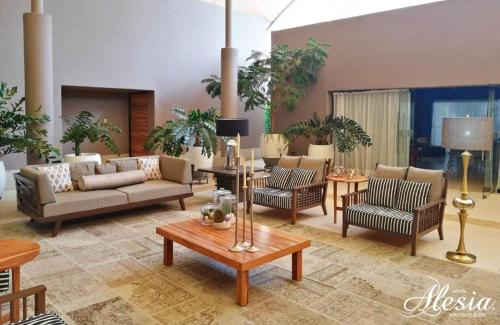 a living room with couches and chairs and a table at Alesia - Boutique Hotel & Spa in Aguascalientes