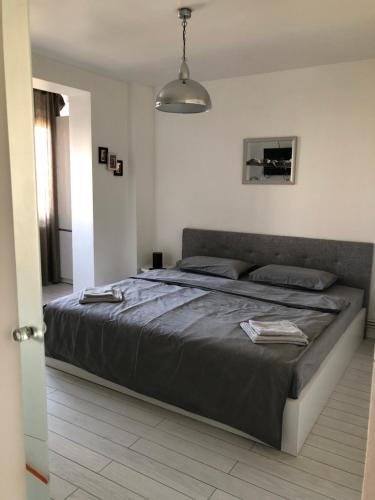 Un dormitorio con una cama grande en una habitación blanca. en Open Space UltraCentral, en Piteşti