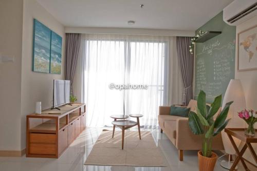 a living room with a couch and a table at OPAHOME@ Timurbay Seafront Residence 2BR Family suite Seaview and Poolview in Kuantan