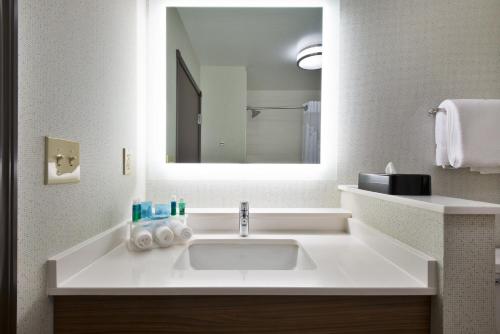 ein Badezimmer mit einem Waschbecken und einem großen Spiegel in der Unterkunft Holiday Inn Express & Suites Uniontown, an IHG Hotel in Uniontown