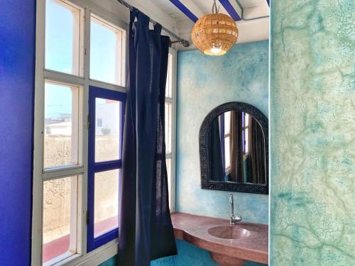 a bathroom with a sink and a mirror at Riad Beldy in Essaouira