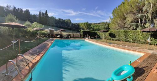 a large blue swimming pool in a yard at Antico Podere Il Bugnolo in Poggibonsi