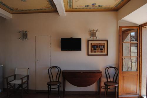una camera con tavolo, sedie e TV a parete di I Balconcini a Siena
