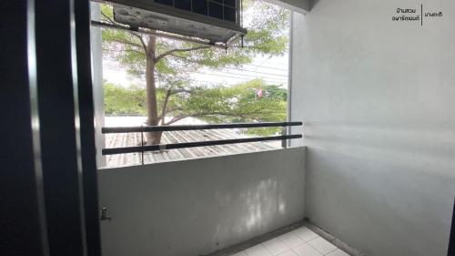 an open door to a window with a tree outside at Bansuay Bangkadi in Pathum Thani