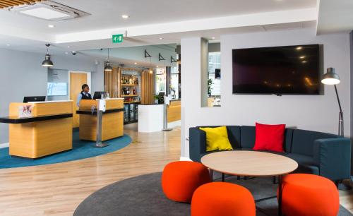 a lobby of an office with a couch and a table at Holiday Inn Express Leeds City Centre - Armouries, an IHG Hotel in Leeds