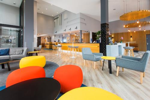 a lobby with chairs and tables and a bar at Holiday Inn Express Leeds City Centre - Armouries by IHG in Leeds