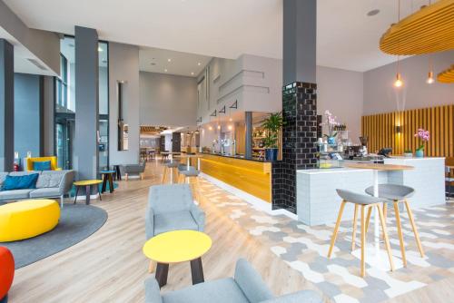 a lobby with chairs and tables and a bar at Holiday Inn Express Leeds City Centre - Armouries by IHG in Leeds