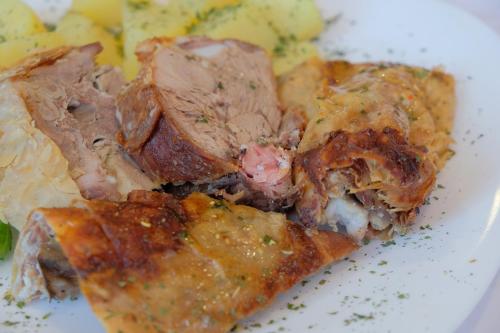 a slice of pizza with meat and potatoes on a plate at Motel Mujanic Sarajevo in Sarajevo