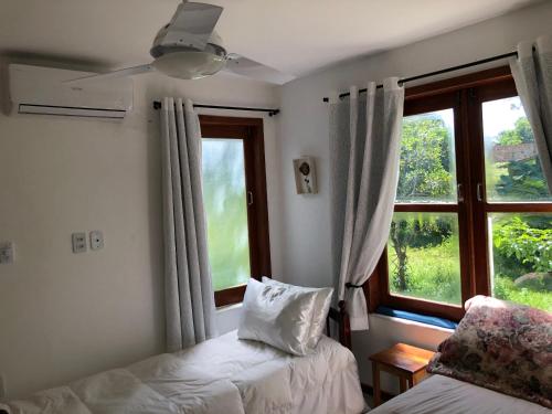 a bedroom with two beds and a window at Casa paradise perto da praia Guarajuba - BA in Camacari