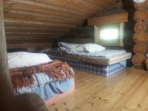 two beds in a attic room with a window at Chalet Ankka in Ruka