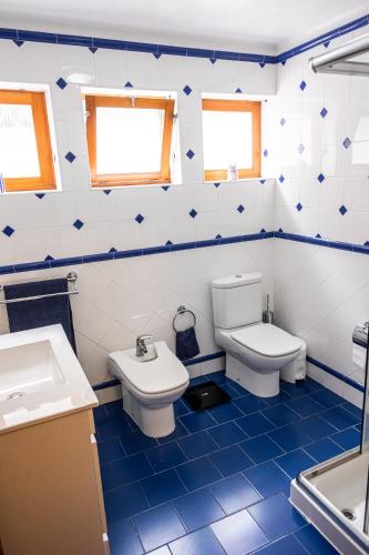 a blue and white bathroom with a toilet and a sink at Snooker House in Ponta Delgada