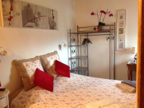 1 dormitorio con 1 cama con almohadas rojas en Chez Marydidou : Chambres d'hôtes, en Istres