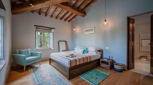 a bedroom with a bed and a chair and a mirror at Palazzone in Torrita di Siena