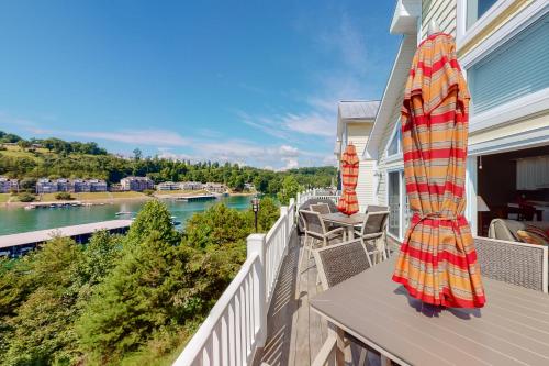 a balcony with an umbrella and a view of a river at Lake Casa in Norris