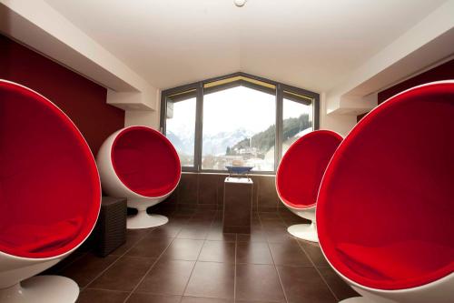 a bathroom with red chairs and a large window at Der Schütthof in Zell am See