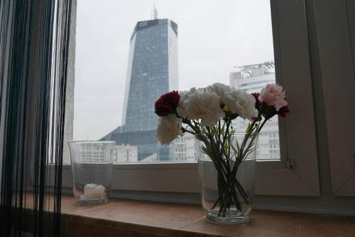 een vaas gevuld met bloemen op een vensterbank bij OhMyHome - View Apartment Grzybowska in Warschau
