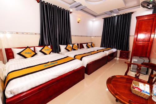 コンダオにあるHotel Hương Đàoのベッドルーム1室(ベッド2台、テーブル、椅子付)