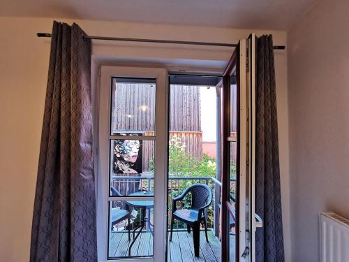 a door to a balcony with a table and a chair at Ferienwohnungen und Ferienhäuser Gohr in Stralsund