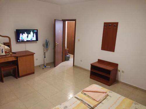 プリモルスコにあるКъща за гости Кадиевиのデスク、壁掛けテレビが備わる客室です。