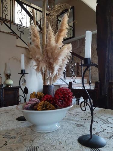 a bowl of fruit on a table with a candle at Os Areeiros Turismo Rural & Bodega in Santa Cristina de Cobres