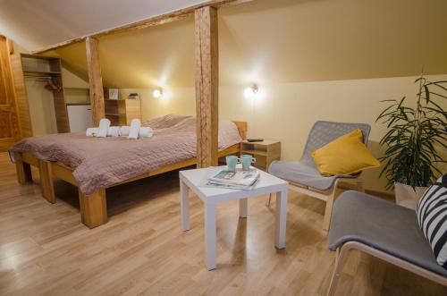 a bedroom with a bed and a table and a chair at Veldzes Nams in Ventspils