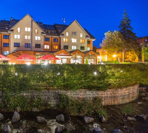 a river in front of buildings at night at Pension Böhmerwald in Železná Ruda