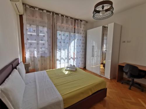 Schlafzimmer mit einem Bett, einem Schreibtisch und einem Fenster in der Unterkunft Pergolesi Apartments in Mailand