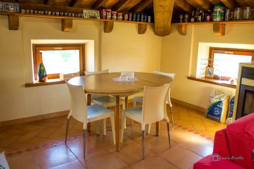 a dining room with a wooden table and chairs at Antiche Vie B&B in Serramazzoni