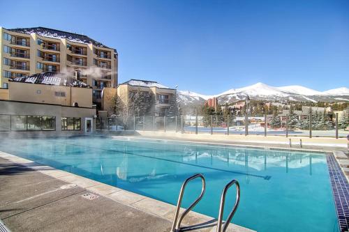 a large blue swimming pool with mountains in the background at Main Street Junction in Breckenridge