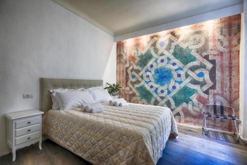 um quarto com uma cama com um quadro na parede em Dimora storica - Palazzo del Taja em Siena