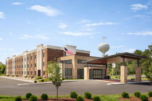 a rendering of the front of a hotel with an american flag at Holiday Inn Express - Plattsburgh by IHG in Plattsburgh