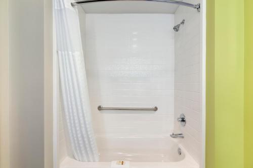 a bathroom with a bath tub with a shower curtain at La Quinta Inn & Suites by Wyndham Braselton in Braselton