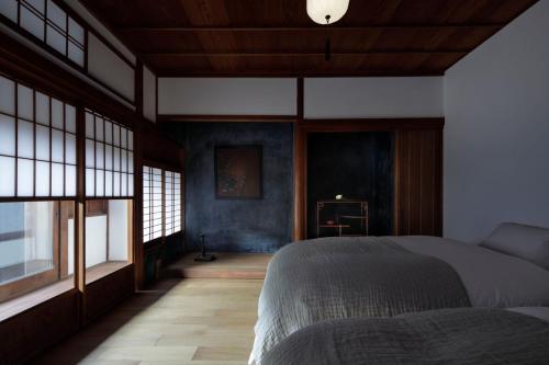 una camera con un letto in una stanza con finestre di MARUYO HOTEL a Kuwana