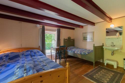 een slaapkamer met 2 bedden en een wastafel bij Landelijk gelegen familieboerderij in Oudelande