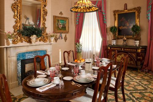 a dining room with a table and a fireplace at Devereaux Shields House in Natchez