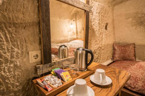 a wooden table with a tea kettle on top of a room at Charming Cave Hotel in Göreme