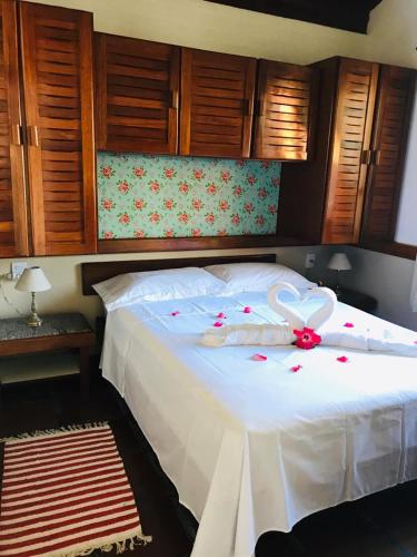 a white bed with a flower on top of it at Casa Chale 10 Florianópolis in Florianópolis