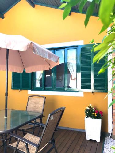 a patio with a table and chairs and an umbrella at Casa Chale 10 Florianópolis in Florianópolis