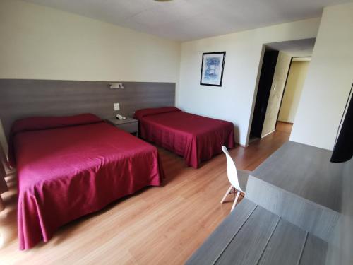 a hotel room with two beds with red sheets at Hotel Del Angel Reforma in Mexico City