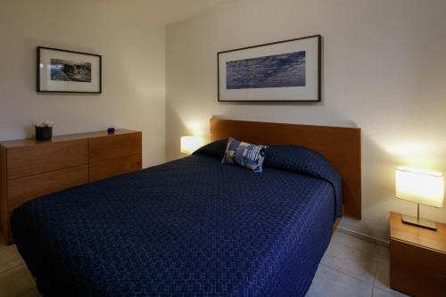 a bedroom with a blue bed and two lamps at Apartamentos West End in Guadalajara