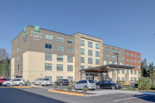a hotel with cars parked in a parking lot at Holiday Inn Express & Suites - Auburn Downtown by IHG in Auburn
