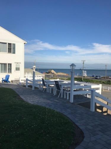 a table and chairs on a patio near a house at Oceanside Condos in Dennis Port