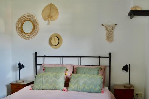 1 dormitorio con 1 cama con almohadas rosas y verdes en Relaxed eigen plekje in de Peel - Kostelijk, en Helenaveen