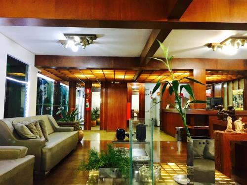 a living room with a couch and a glass table at Minas Palace Hotel in Passos
