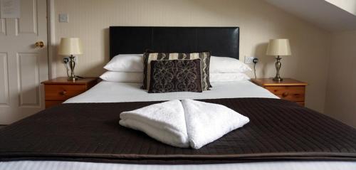 Un pat sau paturi într-o cameră la Ashwood Hotel