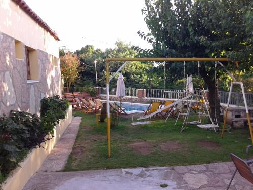 a backyard with a pool and a swing at Hotel El Nogal in La Falda