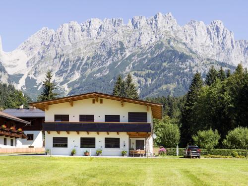 a house with a mountain in the background at otto steiner appartements pension ellmau & wilder kaiser in Ellmau