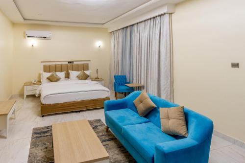 a bedroom with a bed and a blue couch at Hera in Wuse