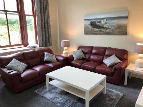 ein Wohnzimmer mit einem Sofa und einem Couchtisch in der Unterkunft The Station Apartment in Kilmarnock