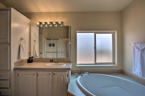 baño con bañera, lavabo y ventana en Moab House Near Arches Natl Park and Canyonlands!, en Moab